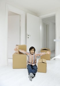 Little boy with moving boxes at new home